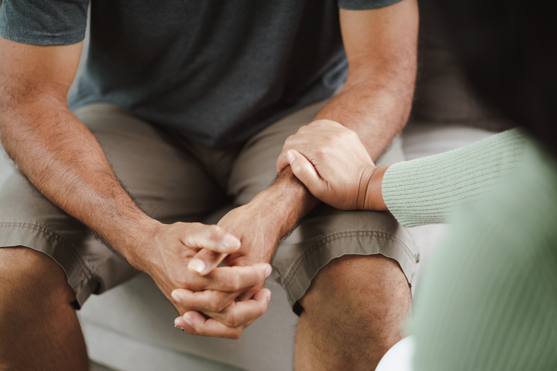 Woman holding the hands of a friend in distress, offering comfort