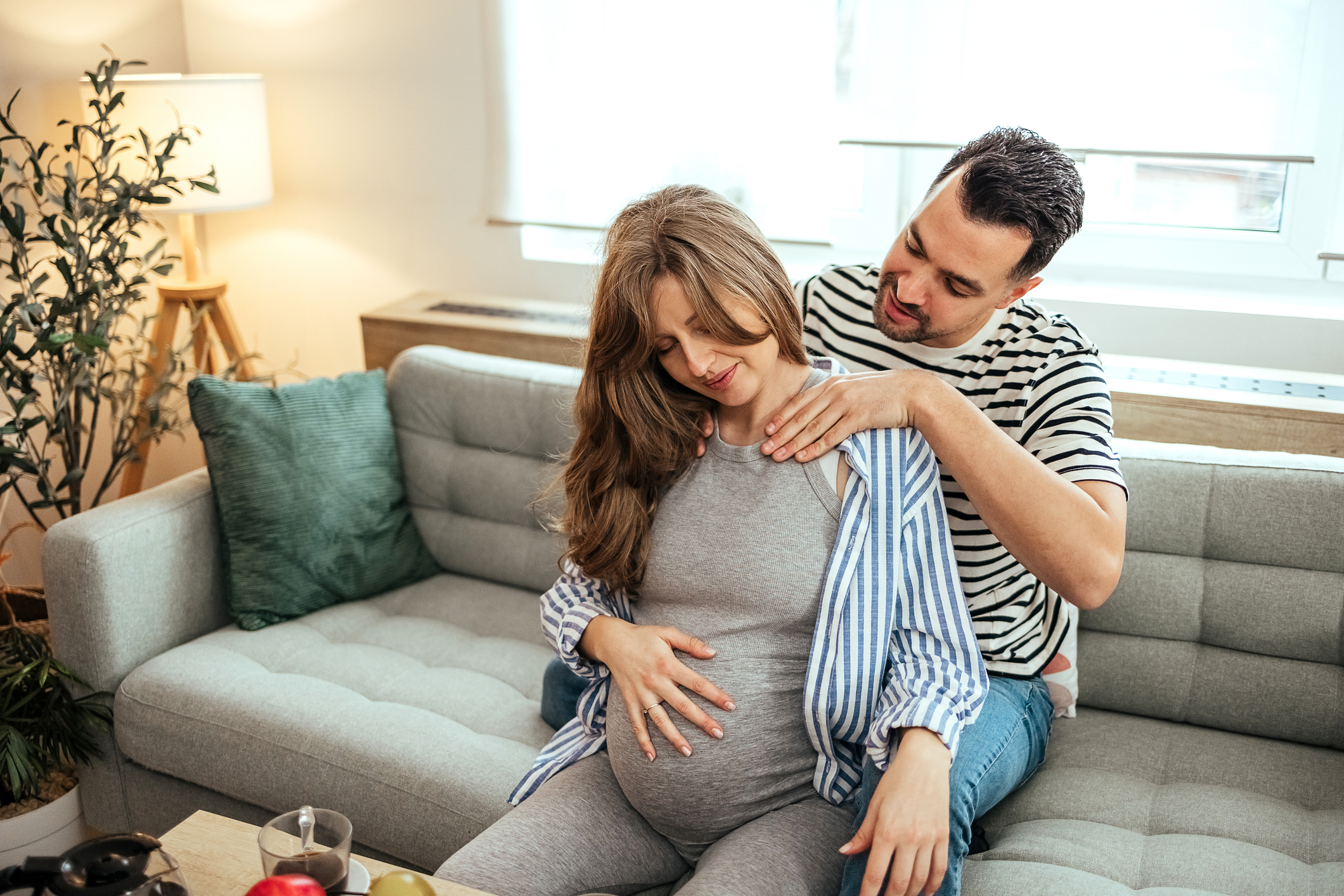Partner giving a soothing massage to pregnant wife, offering loving support